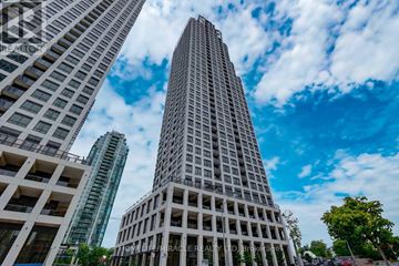 Mississauga (Fairview) condo for rent - A tall building stands in front of two other buildings on a sunny day.