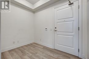 Mississauga (Fairview) condo for rent - A white door is in a room with wood flooring and white walls.
