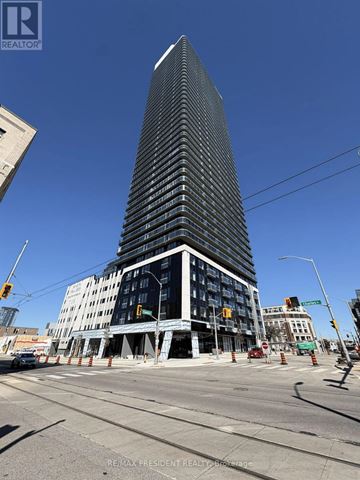 Kitchener condo for rent - A building under construction with a glass facade is visible.