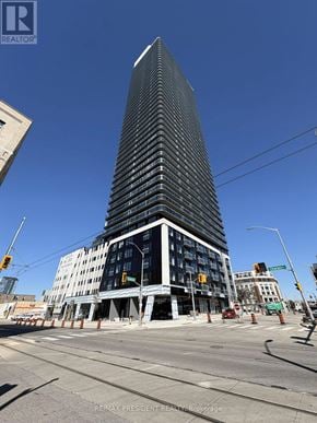 Kitchener condo for rent - A tall building under construction with a blue sky in the background.