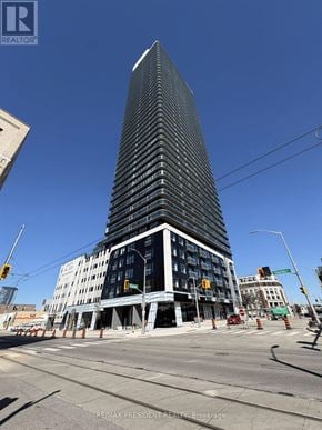 Kitchener condo for rent - A tall building under construction with a blue sky in the background.