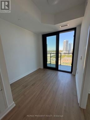 Kitchener condo for rent - A room with a view of a city skyline through the windows.