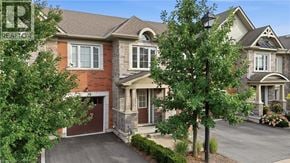 Niagara-On-The-Lake townhouse for rent - A house with a brown garage door is surrounded by greenery.