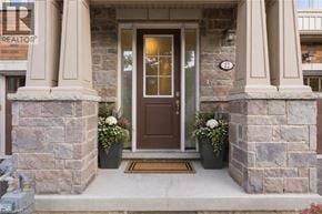 Niagara-On-The-Lake townhouse for rent - A brown door is flanked by two stone pillars.