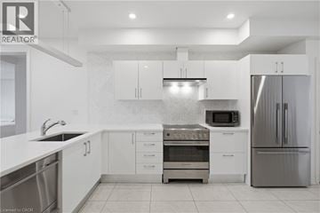 Niagara-On-The-Lake townhouse for rent - A modern kitchen with white cabinets and stainless steel appliances.