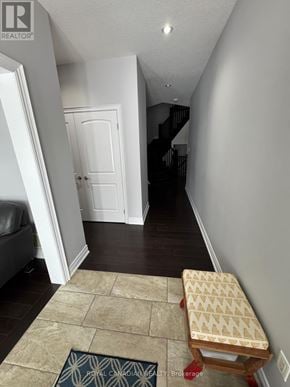 Hamilton (Meadowlands) apartment for rent - A hallway with a bench and a rug that says Royal Canadian Beauty Brokerage.