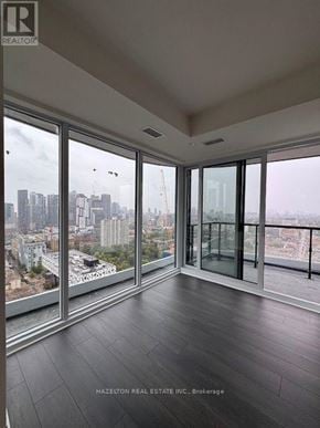 Toronto (Kensington-Chinatown) condo for rent - A room with a view of the cityscape through large windows.