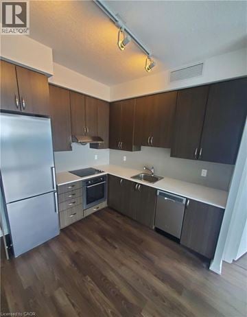 Toronto condo for rent - A kitchen with a refrigerator, sink, and stove.