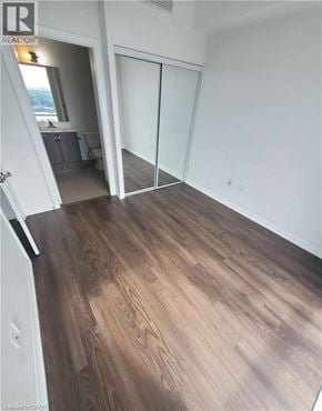 Toronto condo for rent - A room with wood flooring and a sliding glass door.