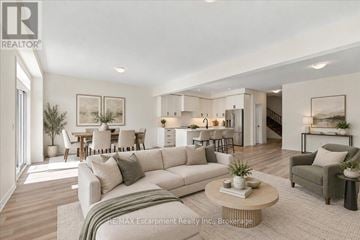 Hamilton (Waterdown) townhouse for rent - A well-lit living room with a large couch and a coffee table.