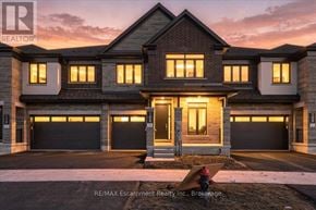 Hamilton (Waterdown) townhouse for rent - A large, modern house with a garage is shown in the image.