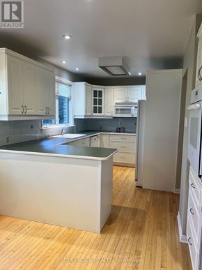 Ottawa apartment for rent - A kitchen with white cabinets and a white refrigerator.