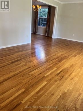 Ottawa apartment for rent - A room with wooden flooring and a doorway leading to another room.