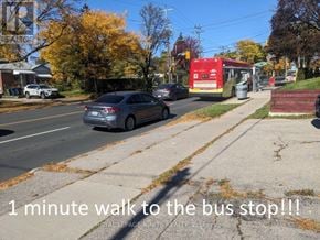 Toronto (Wexford-Maryvale) apartment for rent - A grey car is parked on the side of the road near a bus stop.