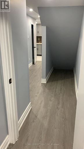 Oshawa (Windfields) apartment for rent - A hallway with a white door and a grey floor.