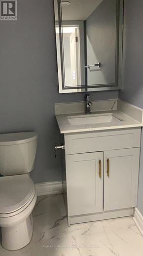 Oshawa (Windfields) apartment for rent - A white toilet sits next to a sink in a bathroom.