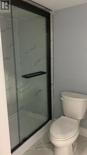 Oshawa (Windfields) apartment for rent - A white toilet in a bathroom with a glass door.