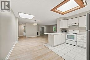 Hamilton apartment for rent - A spacious kitchen with white cabinets and a wooden ceiling.