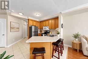 Bradford West Gwillimbury (Bradford) condo for rent - A kitchen with wooden cabinets and a white island.