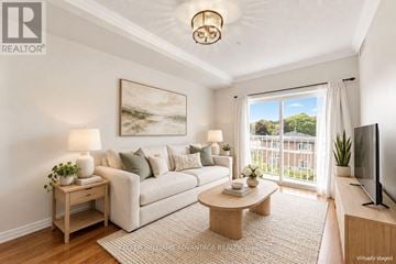 Bradford West Gwillimbury (Bradford) condo for rent - A living room with a white couch, a coffee table, and a painting on the wall.