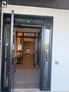 Milton (Cb Cobban) condo for rent - The entrance to a building with a glass door and a sign that reads "REALTOR".