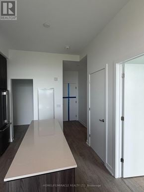 Milton (Cb Cobban) condo for rent - A real estate company is showcasing a modern kitchen with a long countertop and white cabinets.