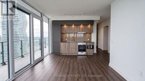 Mississauga (City Centre) condo for rent - A modern living room with a flat screen TV and a kitchenette.