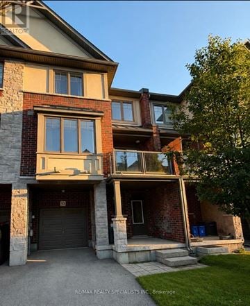 Hamilton (Ancaster) townhouse for rent - A house with a balcony and a garage door.