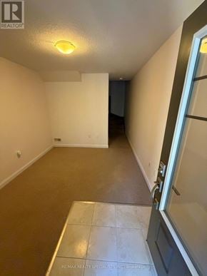 Hamilton (Ancaster) townhouse for rent - A hallway with a tiled floor and a door on the right.