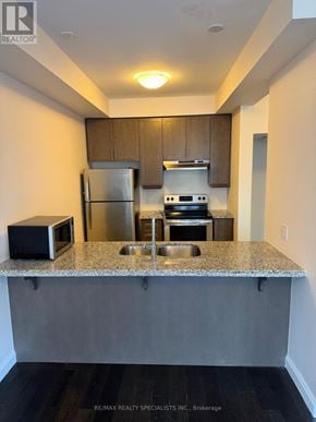 Hamilton (Ancaster) townhouse for rent - A kitchen with a granite countertop and stainless steel appliances.