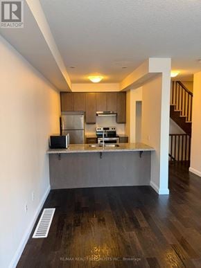 Hamilton (Ancaster) townhouse for rent - A kitchen with a refrigerator, microwave, and oven.