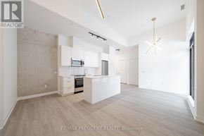 Toronto (Moss Park) condo for rent - A spacious kitchen with white cabinets and a wooden floor.