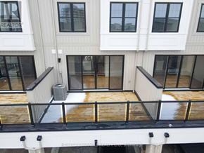 Clarington (Bowmanville) townhouse for rent - A balcony with a railing and a building in the background.