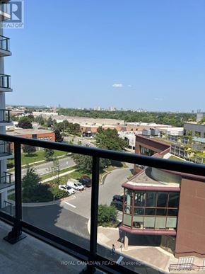 Toronto (York University Heights) condo for rent - A balcony overlooks a parking lot and buildings.