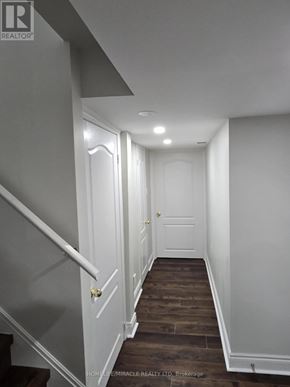 Brampton (Sandringham-Wellington) apartment for rent - A hallway with white walls and a wooden floor.