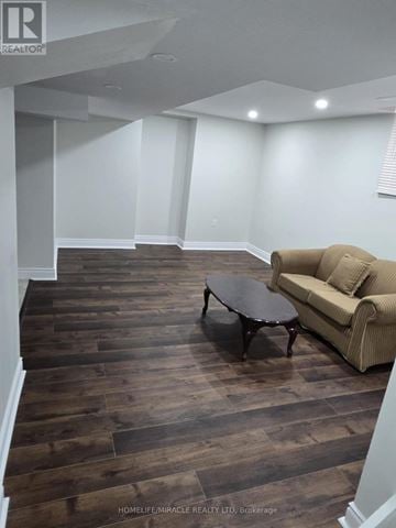 Brampton (Sandringham-Wellington) apartment for rent - A living room with a brown couch and a wooden floor.