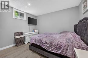 Kitchener apartment for rent - A bedroom with a bed, dresser, and chair.