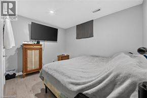 Kitchener apartment for rent - A bedroom with a bed, a TV, and a cabinet.