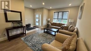 Hamilton (Eleanor) apartment for rent - A living room with a rug, a couch, a coffee table, and a mirror.