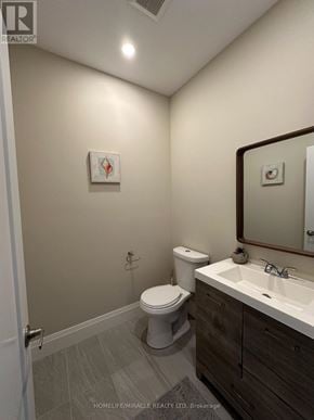 Hamilton (Eleanor) apartment for rent - A bathroom with a toilet, sink, and mirror.