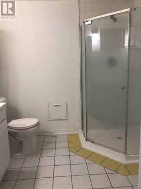 Pickering (Liverpool) apartment for rent - A bathroom with a toilet, a glass shower stall and a yellow mat on the floor.