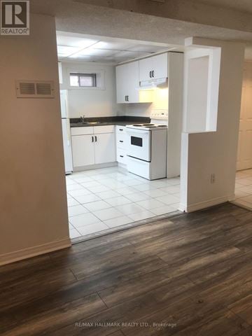 Pickering (Liverpool) apartment for rent - A kitchen with white cabinets and a black countertop.