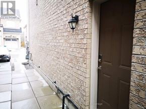 Markham (Cedarwood) apartment for rent - A brown door is on the right side of a brick wall.