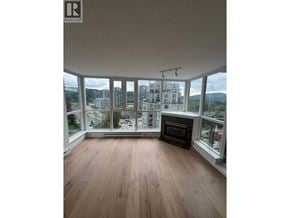 Port Moody apartment for rent - A large, empty room with wooden floors and a fireplace.