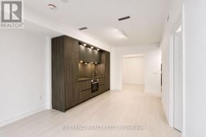 Toronto (Waterfront Communities) condo for rent - A spacious room with a kitchen area and a hallway.