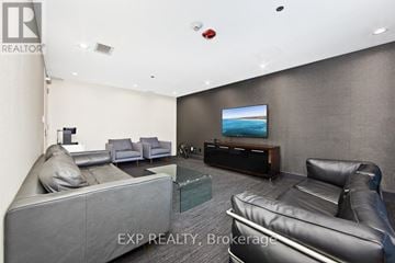 Toronto (Casa Loma) condo for rent - A living room with grey and black leather furniture and a flat screen TV.