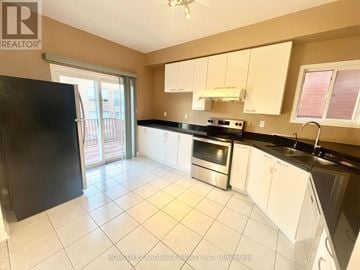 Markham (Berczy) apartment for rent - A kitchen with white cabinets and black countertops is on the market.