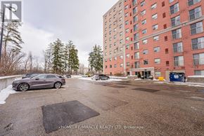 Waterloo multi-family for rent - A parking lot with a building in the background and a car parked in the lot.