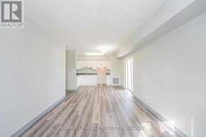 Waterloo multi-family for rent - A spacious room with wooden flooring and white walls, with a logo for REALTOR® in the top left corner.