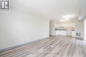 Waterloo multi-family for rent - A spacious room with wooden flooring and white walls, likely a living room or a similar open space.